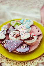 imagery holiday themed sugar cookies on a plate, there is a cupcake on the plate aswell